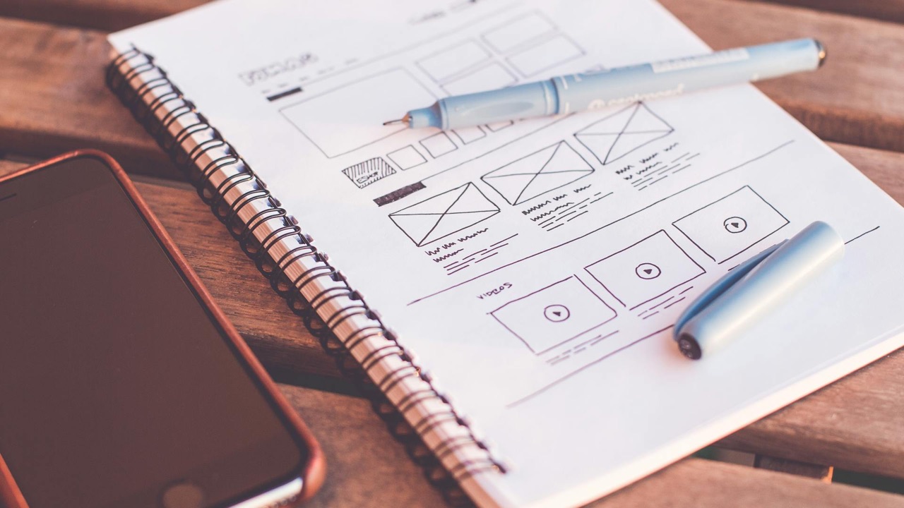 Website wireframe sketches on a notebook representing UX design and conversion architecture